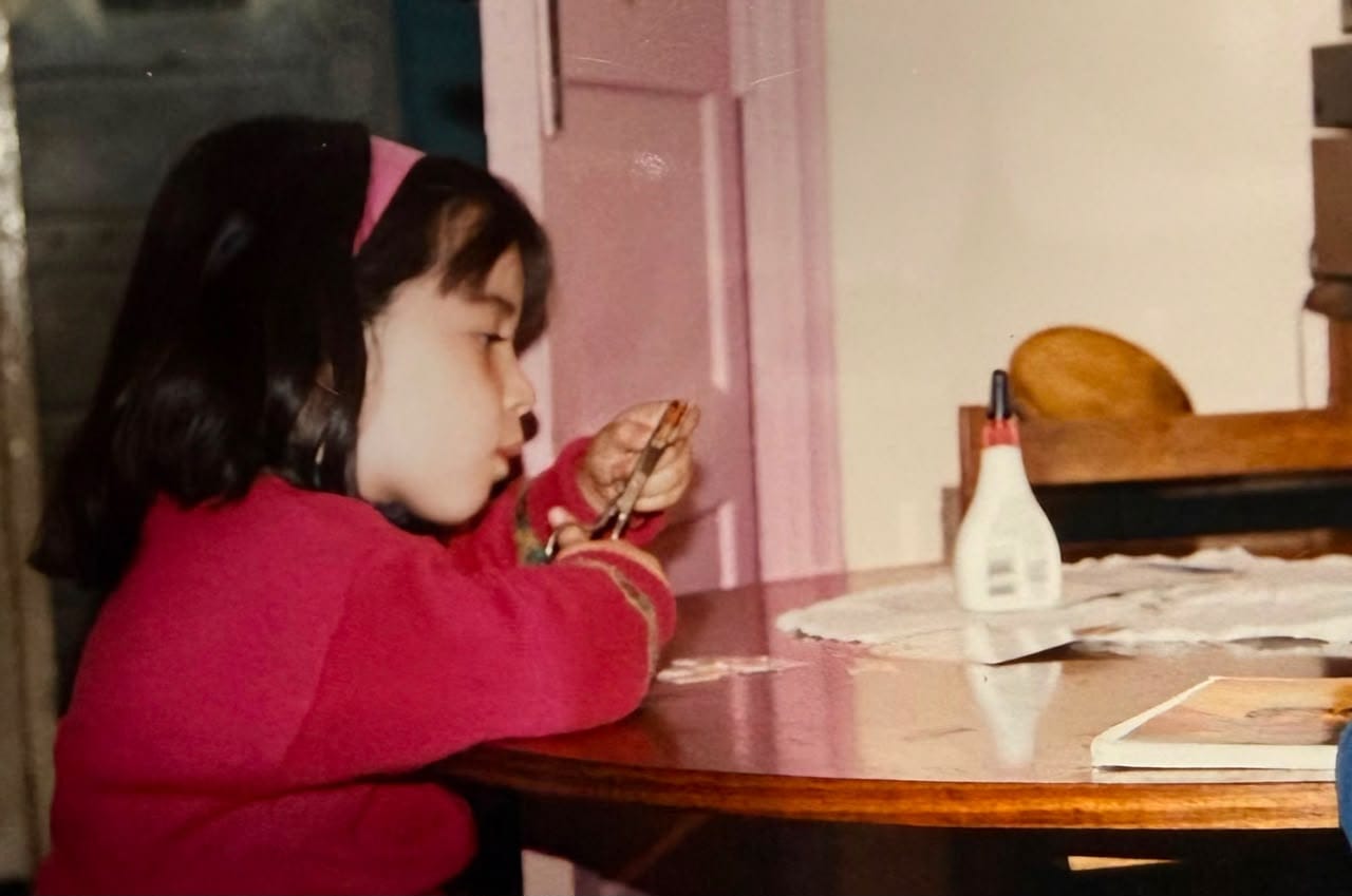Niña de los años 90s recortando papeles